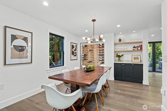 dining area featuring baseboards, recessed lighting, an inviting chandelier, and light wood-style flooring
