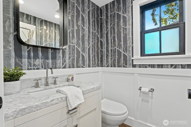 bathroom with toilet, vanity, and recessed lighting