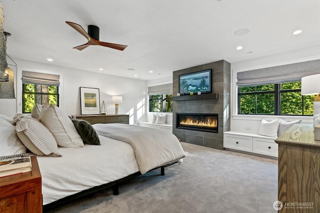 bedroom featuring a fireplace, recessed lighting, and multiple windows