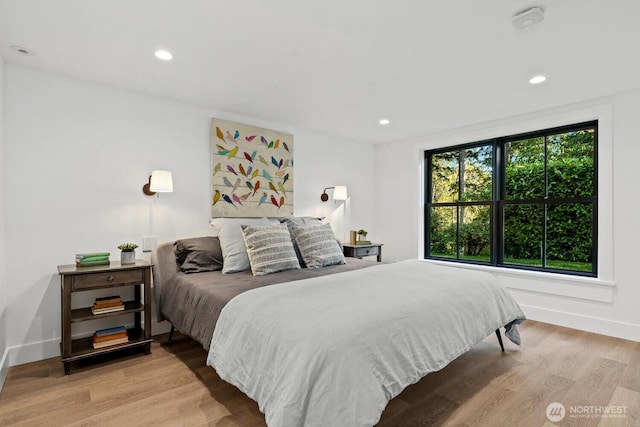 bedroom with baseboards, wood finished floors, and recessed lighting