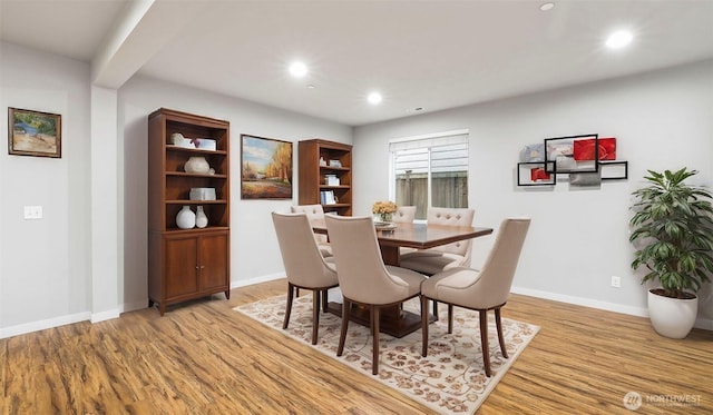 dining space with baseboards, light wood finished floors, and recessed lighting