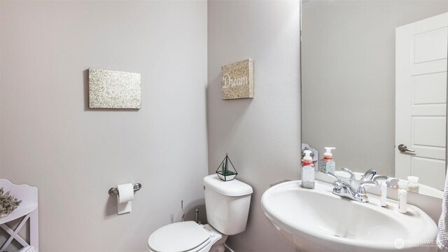 half bathroom with a sink and toilet