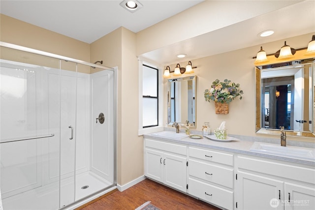 full bath featuring a shower stall, wood finished floors, and a sink