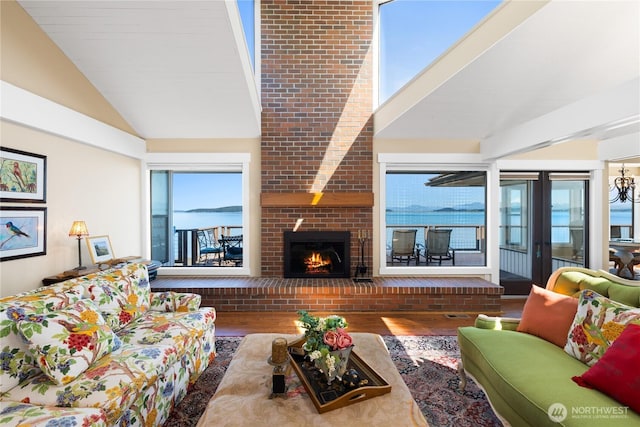 living area featuring lofted ceiling, a brick fireplace, and wood finished floors