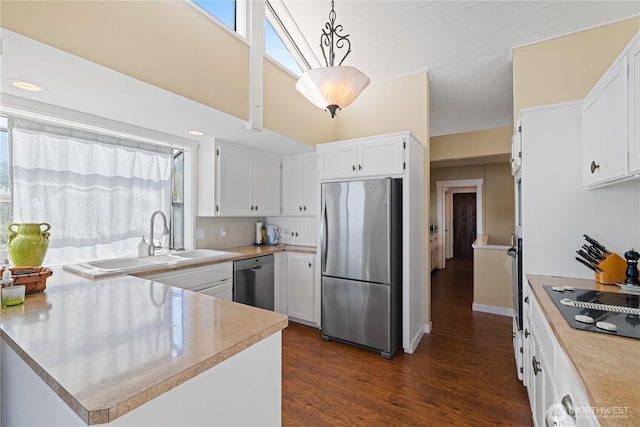 kitchen with a sink, white cabinetry, light countertops, appliances with stainless steel finishes, and dark wood-type flooring