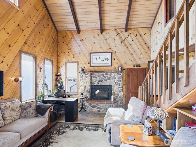 living area with wood finished floors, vaulted ceiling with beams, a healthy amount of sunlight, wooden ceiling, and wood walls