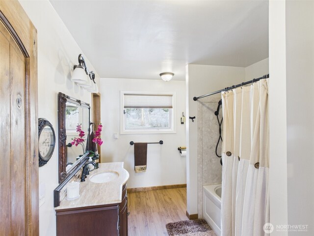 bathroom with shower / bath combination with curtain, baseboards, vanity, and wood finished floors