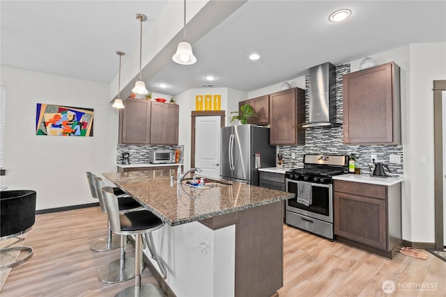 17431 3rd Ave SE, Bothell, WA 98012 - kitchen featuring stainless steel appliances, wall chimney range hood, a sink, backsplash, and light wood-style floors