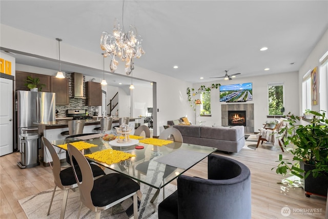 17431 3rd Ave SE, Bothell, WA 98012 - dining space with light wood-style floors, ceiling fan, recessed lighting, a tile fireplace, and a chandelier