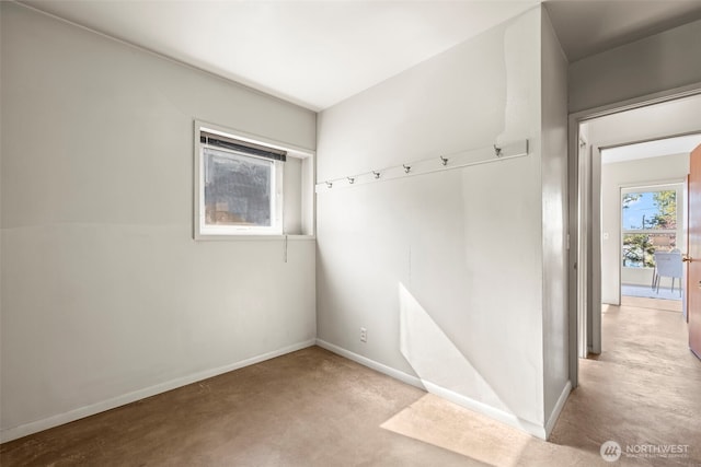 carpeted spare room featuring baseboards