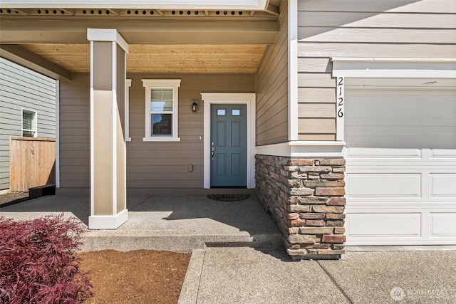 2126 Olivia St SE, Olympia, WA 98513 - property entrance featuring covered porch, stone siding, and a garage