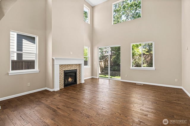 2126 Olivia St SE, Olympia, WA 98513 - unfurnished living room featuring dark wood-style floors, a tiled fireplace, baseboards, and a towering ceiling