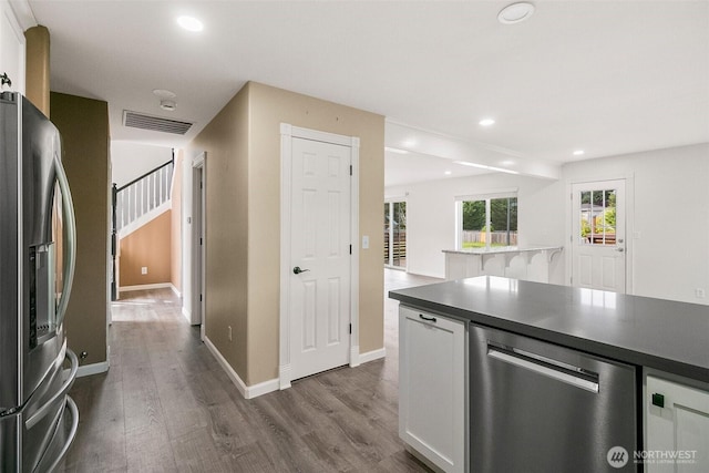 2734 Thornhill Rd SE, Puyallup, WA 98374 - kitchen with stainless steel appliances, dark wood-style flooring, white cabinetry, recessed lighting, and dark countertops