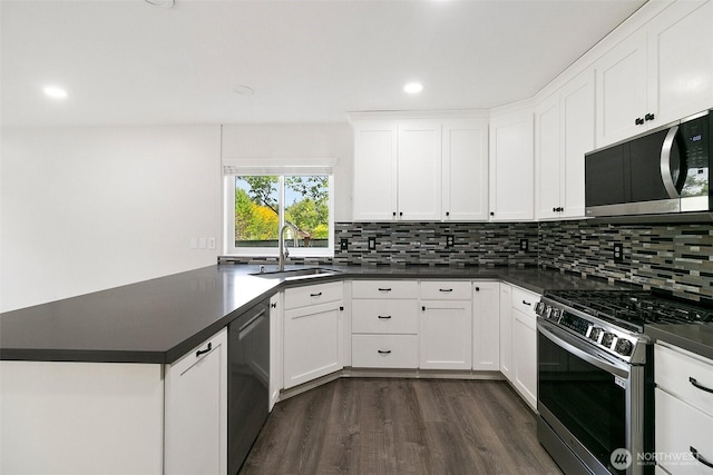 2734 Thornhill Rd SE, Puyallup, WA 98374 - kitchen with stainless steel appliances, a sink, dark countertops, dark wood-style flooring, and tasteful backsplash
