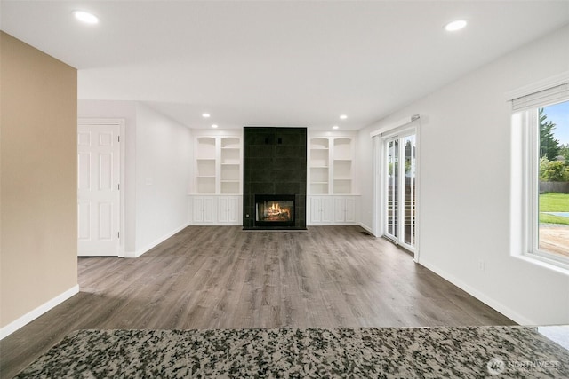 2734 Thornhill Rd SE, Puyallup, WA 98374 - unfurnished living room with wood finished floors, baseboards, recessed lighting, a fireplace, and built in shelves