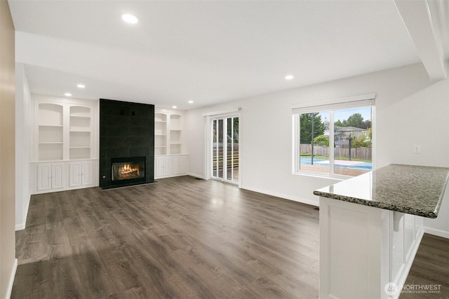 2734 Thornhill Rd SE, Puyallup, WA 98374 - unfurnished living room with dark wood-type flooring, baseboards, recessed lighting, and a large fireplace