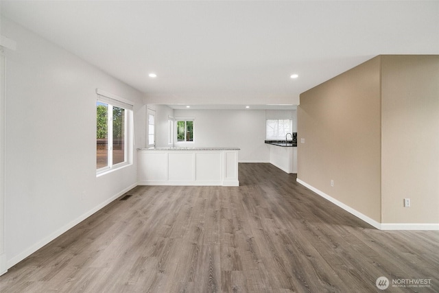 2734 Thornhill Rd SE, Puyallup, WA 98374 - unfurnished living room featuring wood finished floors, baseboards, and recessed lighting