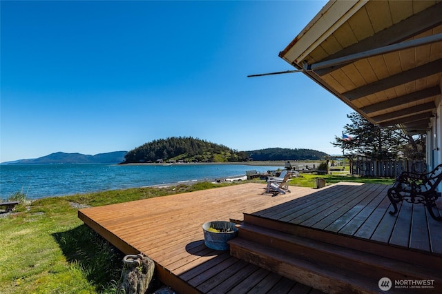 wooden deck featuring a water and mountain view