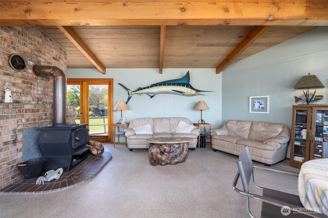 carpeted living area with a wood stove, vaulted ceiling with beams, and wooden ceiling
