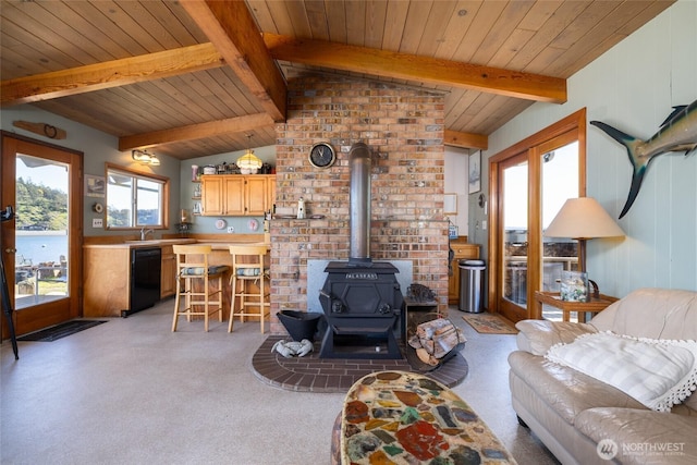 living room featuring light carpet, vaulted ceiling with beams, wooden ceiling, and a wood stove