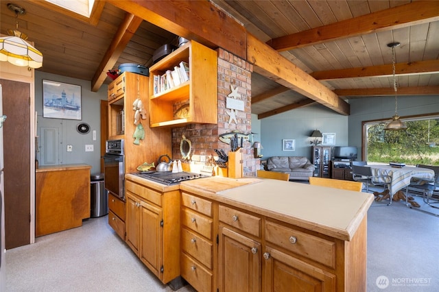 kitchen featuring stainless steel appliances, light countertops, wood ceiling, vaulted ceiling with skylight, and light colored carpet