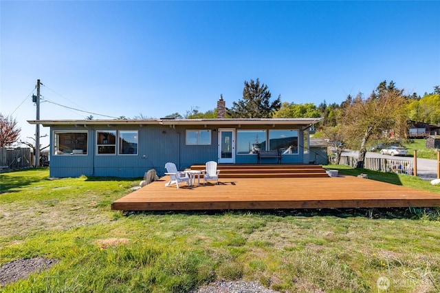 back of house featuring fence, a yard, and a deck