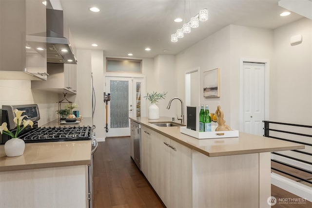 kitchen with a kitchen island with sink, wall chimney range hood, recessed lighting, a sink, and stainless steel appliances