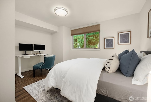 bedroom with baseboards and wood finished floors