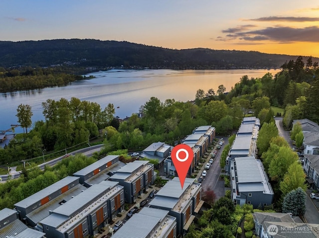 aerial view at dusk featuring a water view
