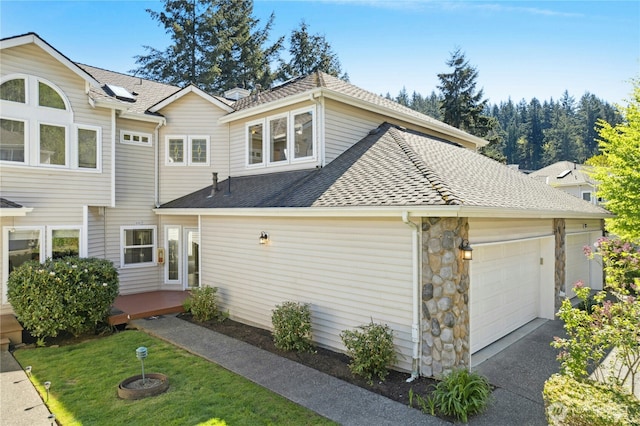 9821 NE Riverbend Dr Unit C102, Bothell, WA 98011 - view of side of home featuring a garage, a shingled roof, driveway, and stone siding