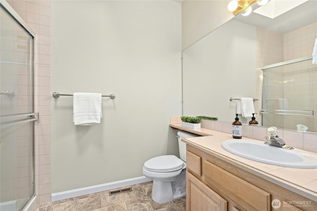 9821 NE Riverbend Dr Unit C102, Bothell, WA 98011 - bathroom featuring vanity, toilet, a tile shower, and baseboards