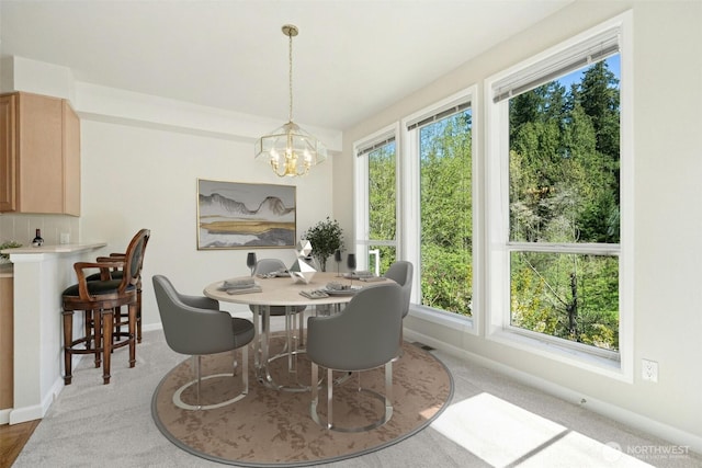 9821 NE Riverbend Dr Unit C102, Bothell, WA 98011 - dining area with a chandelier, plenty of natural light, baseboards, and light carpet