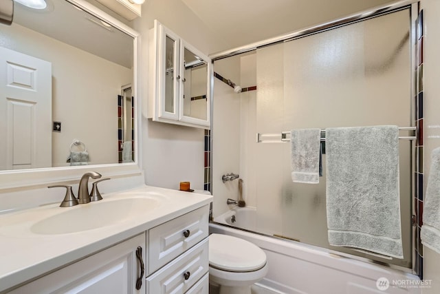 bathroom with vanity, shower / bath combination with glass door, and toilet