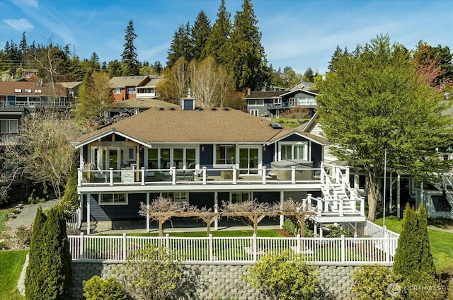 back of house with a fenced backyard and a balcony