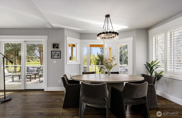 dining area with baseboards, a wealth of natural light, a chandelier, and dark wood finished floors