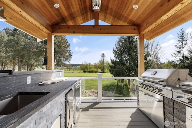 wooden deck with a yard, a sink, and area for grilling