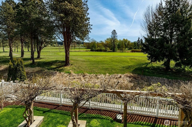 view of community featuring fence and a lawn