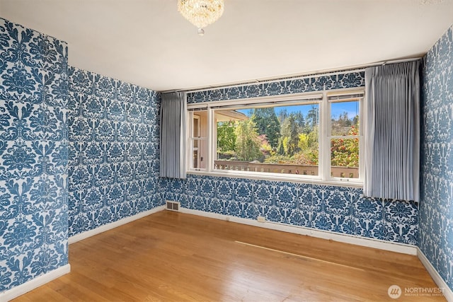 5429 NE Windermere Rd, Seattle, WA 98105 - empty room featuring visible vents, baseboards, wood finished floors, and wallpapered walls