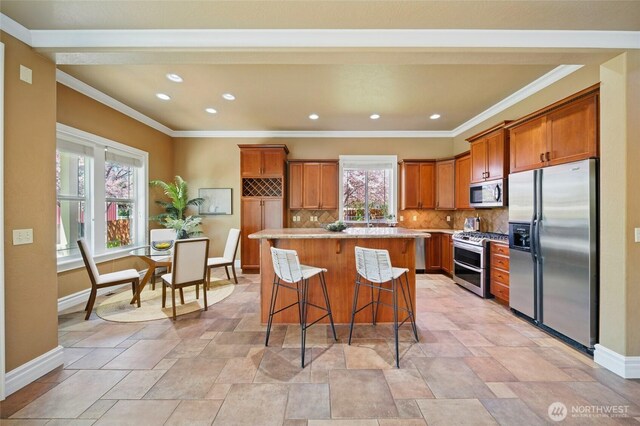 162 Costello Pl, Walla Walla, WA 99362 - kitchen with brown cabinets, stainless steel appliances, stone finish flooring, baseboards, and a kitchen island