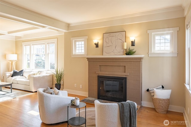 living area featuring beamed ceiling, wood finished floors, a brick fireplace, and crown molding