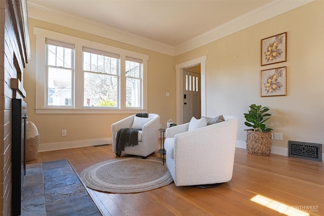 living room featuring baseboards, wood finished floors, visible vents, and crown molding