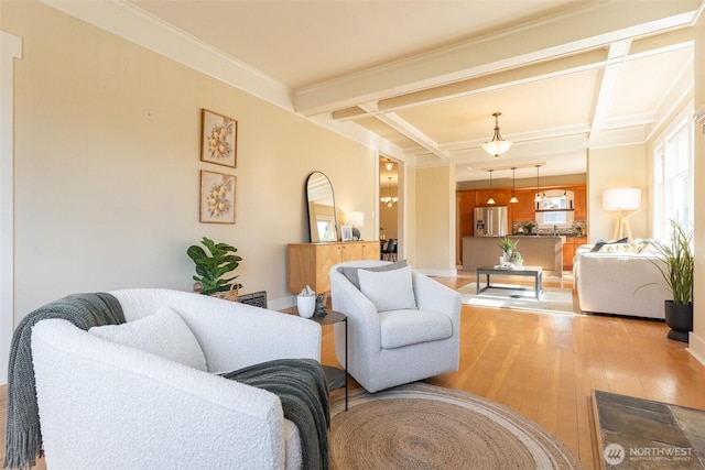 living room featuring coffered ceiling, crown molding, wood finished floors, and beamed ceiling