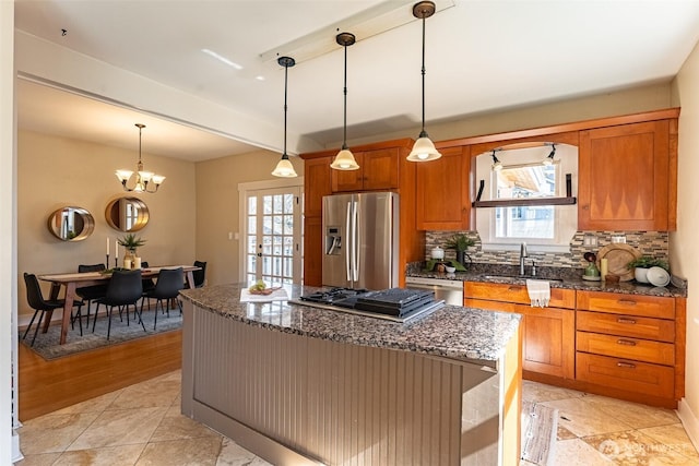 kitchen with brown cabinetry, a wealth of natural light, stainless steel appliances, and a sink