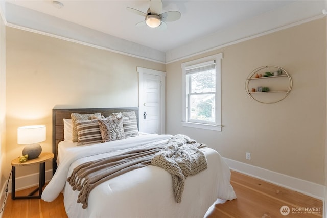 bedroom featuring baseboards, wood finished floors, ceiling fan, and crown molding