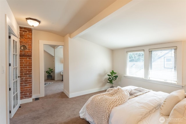 carpeted bedroom featuring lofted ceiling and baseboards