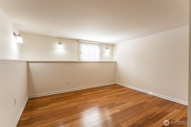 unfurnished room with baseboards and wood finished floors