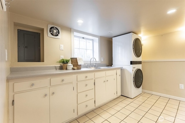 laundry area with recessed lighting, stacked washer / dryer, a sink, light tile patterned flooring, and cabinet space