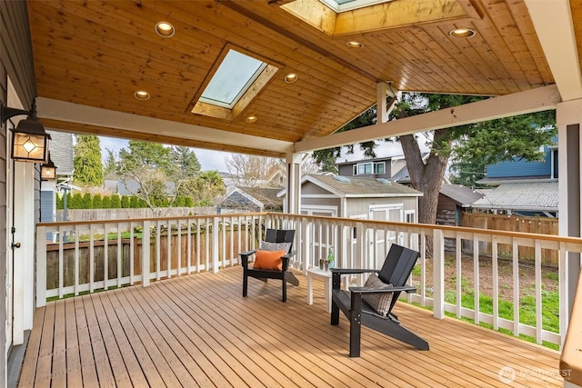 wooden deck with a fenced backyard, an outbuilding, and a storage unit