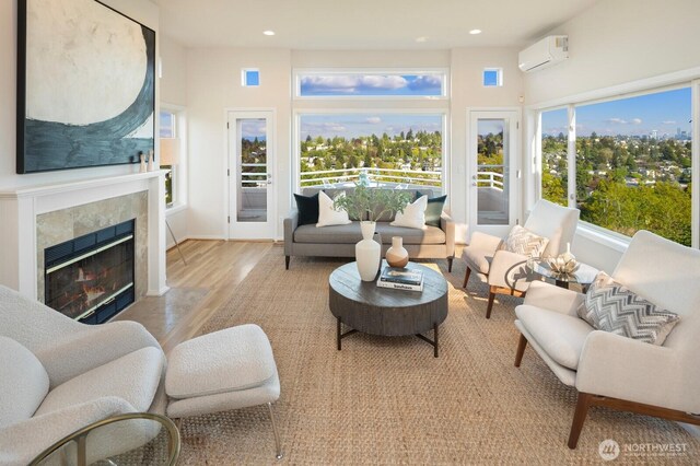 living area featuring a wall mounted air conditioner, wood finished floors, recessed lighting, and a tiled fireplace