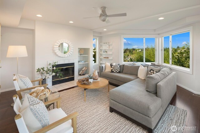living room with baseboards, ceiling fan, recessed lighting, wood finished floors, and a tiled fireplace